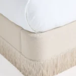 krem karyola, saçak detaylı yatak, baza tipi yatak modeli, zarif başlıklı yatak, minimal tasarım karyola, döşemeli modern yatak, yumuşak hatlı baza, iç mekan için şık yatak, iç mimari yatak önerisi, sade çizgili yatak tasarımı, lüks kumaş kaplama baza, özel ölçü karyola, sipariş üzerine üretilen yatak, Talent Design yatak modeli, Esra koleksiyon karyola, dekoratif baza modeli, iç mekana uyumlu zarif karyola, modern klasik yatak stili, ısmarlama üretim baza yatak, kişiye özel üretim yatak